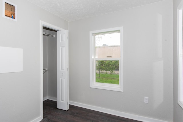 1226 Shakespeare Ave, Kalamazoo, MI 49001 - unfurnished bedroom featuring dark wood-style floors, baseboards, and a textured ceiling