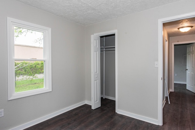 1226 Shakespeare Ave, Kalamazoo, MI 49001 - unfurnished bedroom with dark wood-type flooring, a textured ceiling, baseboards, and a closet