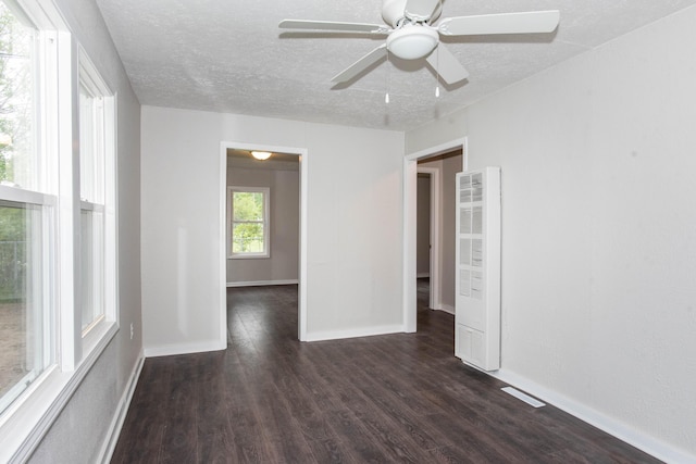 1226 Shakespeare Ave, Kalamazoo, MI 49001 - empty room featuring a heating unit, dark wood-type flooring, a textured ceiling, a ceiling fan, and baseboards