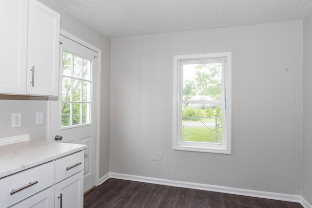 1226 Shakespeare Ave, Kalamazoo, MI 49001 - unfurnished dining area featuring dark wood-style flooring, baseboards, and a textured ceiling
