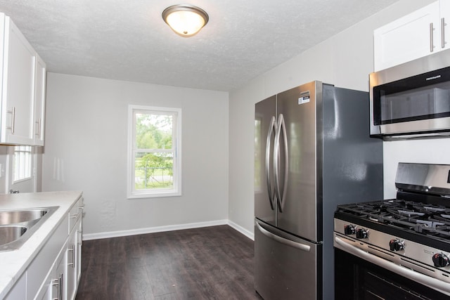1226 Shakespeare Ave, Kalamazoo, MI 49001 - kitchen featuring appliances with stainless steel finishes, dark wood-type flooring, baseboards, a textured ceiling, and light countertops
