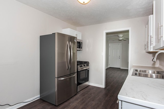 1226 Shakespeare Ave, Kalamazoo, MI 49001 - kitchen with stainless steel appliances, a sink, white cabinetry, dark wood-style floors, and a textured ceiling