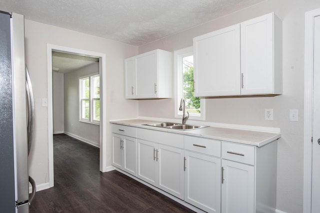 1226 Shakespeare Ave, Kalamazoo, MI 49001 - kitchen with a sink, freestanding refrigerator, dark wood-type flooring, light countertops, and white cabinetry