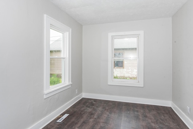 1226 Shakespeare Ave, Kalamazoo, MI 49001 - empty room featuring dark wood-type flooring, baseboards, and a textured ceiling