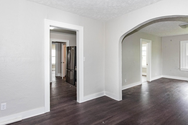 1226 Shakespeare Ave, Kalamazoo, MI 49001 - spare room with arched walkways, dark wood-style flooring, a textured ceiling, and baseboards