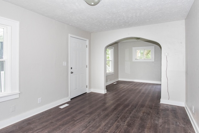1226 Shakespeare Ave, Kalamazoo, MI 49001 - spare room with arched walkways, dark wood finished floors, a textured ceiling, and baseboards
