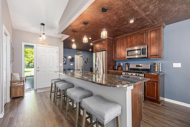 4465 Spinnaker Ln, Pleasant Lake, MI 49272 - kitchen featuring appliances with stainless steel finishes, dark wood-style floors, baseboards, a breakfast bar, and dark stone counters