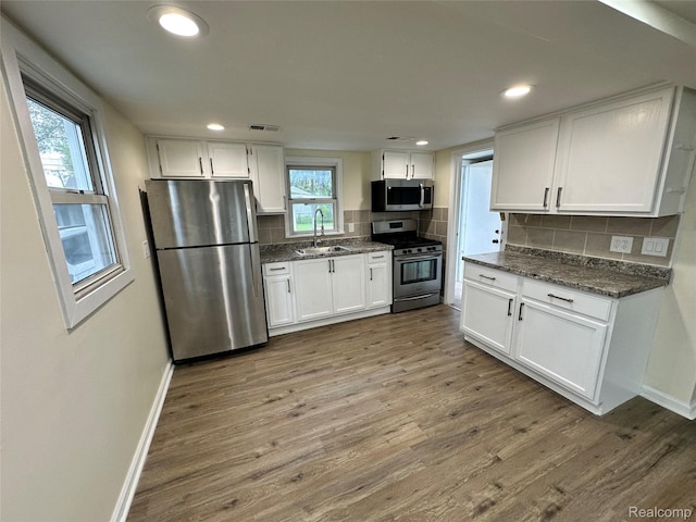 33050 John Hauk St, Garden City, MI 48135 - kitchen with appliances with stainless steel finishes, a sink, baseboards, wood finished floors, and white cabinetry