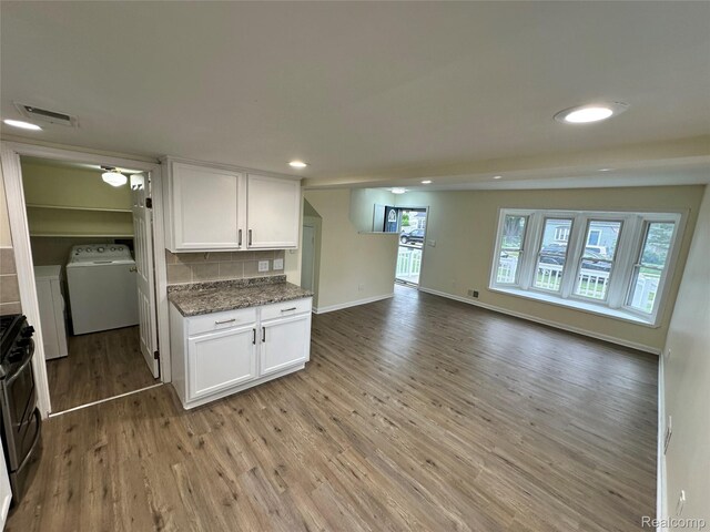 33050 John Hauk St, Garden City, MI 48135 - kitchen with washer / clothes dryer, light wood-style floors, white cabinetry, gas stove, and tasteful backsplash