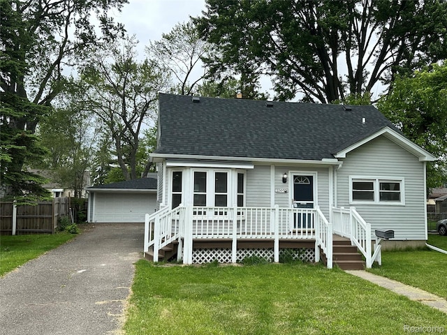 33050 John Hauk St, Garden City, MI 48135 - view of front of house featuring a shingled roof, a detached garage, a wooden deck, and an outbuilding