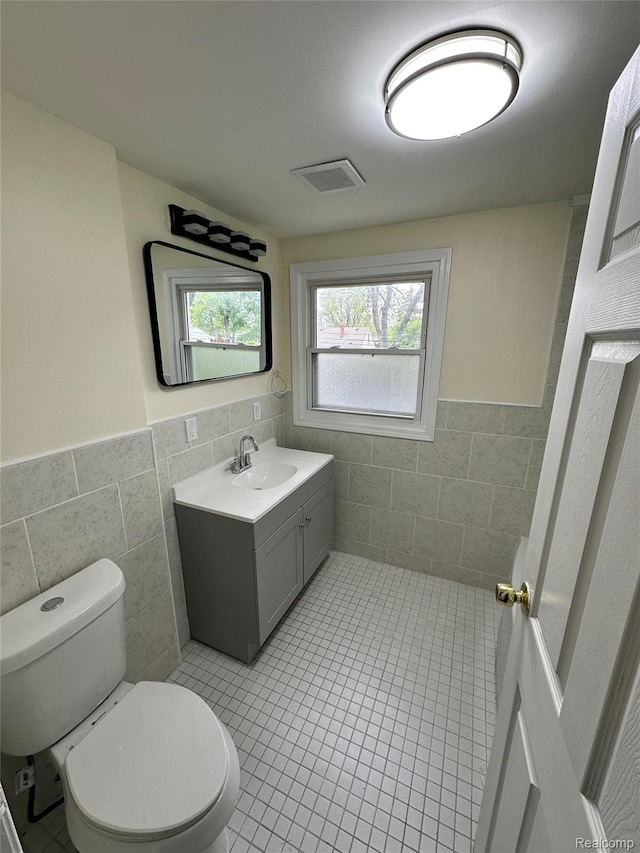 33050 John Hauk St, Garden City, MI 48135 - bathroom with tile walls, toilet, vanity, wainscoting, and tile patterned floors