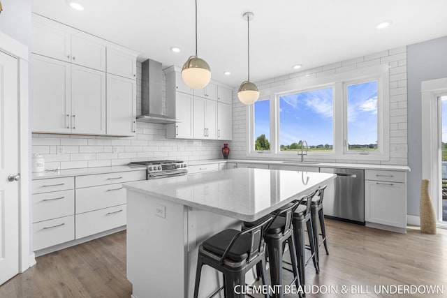 13944 Harrington Lndg, Holland, MI 49424 - kitchen with appliances with stainless steel finishes, wall chimney range hood, a sink, healthy amount of natural light, and recessed lighting
