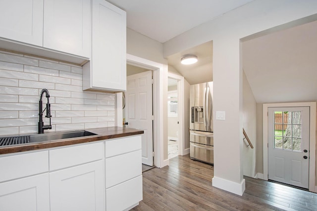 1538 Rossman Ave SE, Grand Rapids, MI 49507 - kitchen with a sink, stainless steel refrigerator with ice dispenser, dark wood-style floors, white cabinets, and butcher block counters