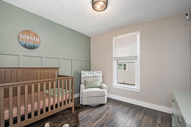 1538 Rossman Ave SE, Grand Rapids, MI 49507 - bedroom with hardwood / wood-style flooring, a decorative wall, baseboards, wainscoting, and a textured ceiling