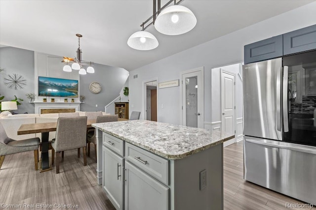 2941 Yosemite Dr, Orion, MI 48360 - kitchen featuring smart refrigerator, a center island, wood finished floors, and a chandelier