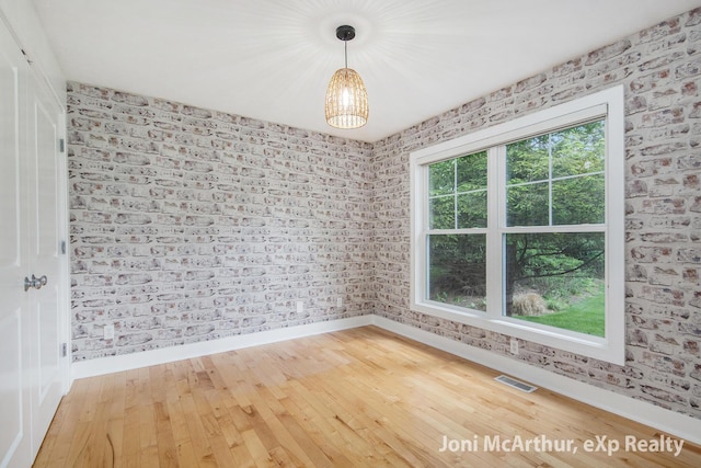 13 Foleys Grade, Lowell, MI 49331 - empty room with baseboards, wood-type flooring, and a chandelier