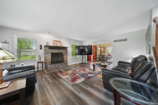 9428 Talladay Rd, Willis, MI 48191 - living room with wood finished floors, arched walkways, a chandelier, a fireplace, and baseboards
