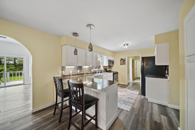 9428 Talladay Rd, Willis, MI 48191 - kitchen with stainless steel appliances, decorative backsplash, dark wood-type flooring, and healthy amount of natural light
