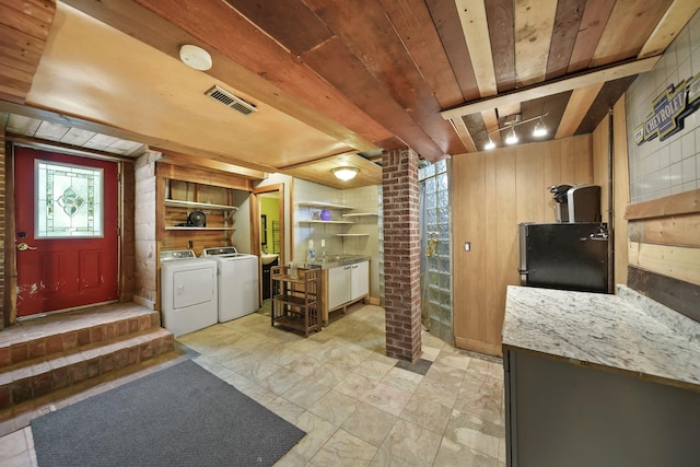 9428 Talladay Rd, Willis, MI 48191 - kitchen with washing machine and clothes dryer, wooden walls, freestanding refrigerator, and wooden ceiling