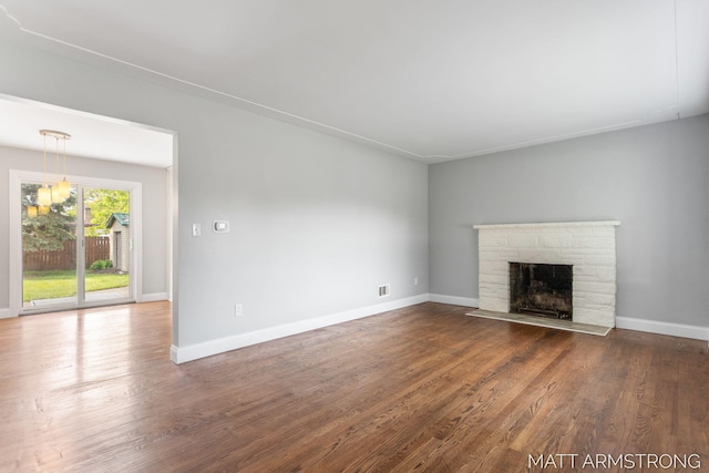 1272 Den Hertog St SW, Wyoming, MI 49509 - unfurnished living room featuring a stone fireplace, wood finished floors, and baseboards