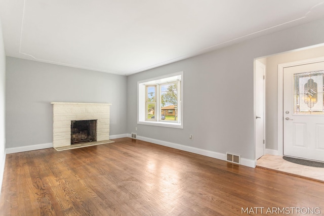 1272 Den Hertog St SW, Wyoming, MI 49509 - unfurnished living room featuring a stone fireplace, wood finished floors, and baseboards