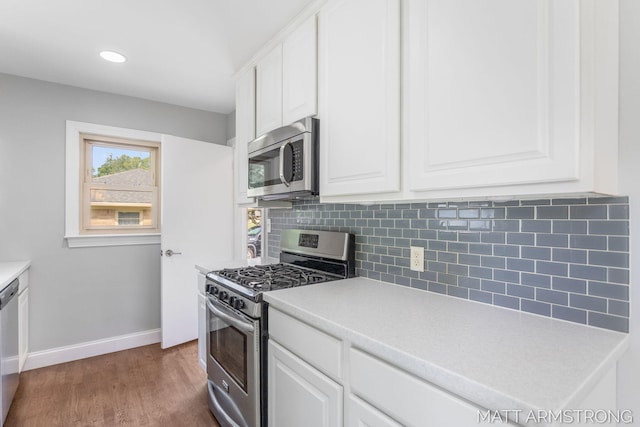1272 Den Hertog St SW, Wyoming, MI 49509 - kitchen featuring appliances with stainless steel finishes, backsplash, baseboards, white cabinetry, and recessed lighting