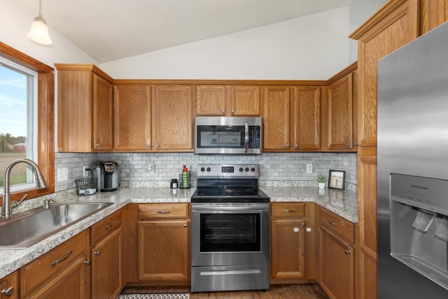 1443 140th Ave, Wayland, MI 49348 - kitchen featuring appliances with stainless steel finishes, lofted ceiling, a sink, decorative backsplash, and brown cabinetry