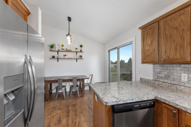 1443 140th Ave, Wayland, MI 49348 - kitchen with stainless steel appliances, vaulted ceiling, brown cabinets, dark wood-style floors, and a peninsula