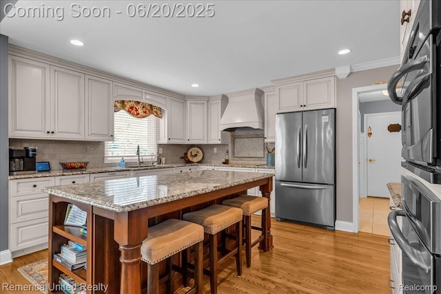 22858 Saint George Cir S, Lyon, MI 48178 - kitchen featuring freestanding refrigerator, premium range hood, backsplash, a center island, and recessed lighting