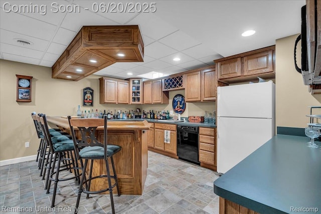22858 Saint George Cir S, Lyon, MI 48178 - kitchen with freestanding refrigerator, dishwasher, a breakfast bar, stone finish floors, and a drop ceiling