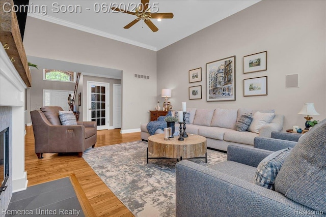 22858 Saint George Cir S, Lyon, MI 48178 - living area featuring a ceiling fan, wood finished floors, crown molding, and a glass covered fireplace