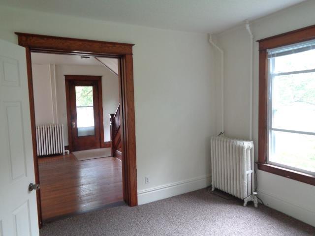 510 S Main, Mount Pleasant, MI 48858 - carpeted empty room featuring radiator and baseboards