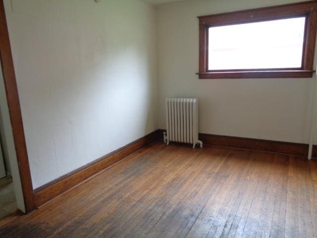 510 S Main, Mount Pleasant, MI 48858 - empty room with radiator heating unit, wood-type flooring, and baseboards
