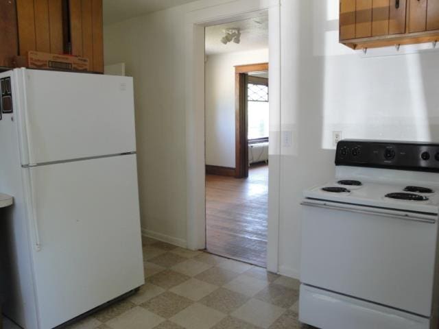 510 S Main, Mount Pleasant, MI 48858 - kitchen featuring white appliances, light flooring, baseboards, brown cabinetry, and light countertops