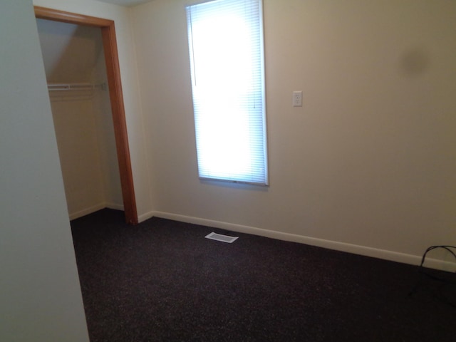 1020 S Lansing, Mount Pleasant, MI 48858 - unfurnished bedroom with dark carpet, baseboards, and a closet