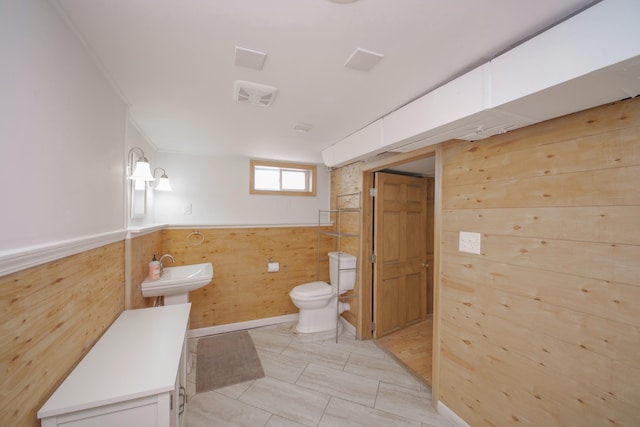 2720 Willa Dr, Saint Joseph, MI 49085 - bathroom featuring toilet, a sink, a wainscoted wall, and wooden walls
