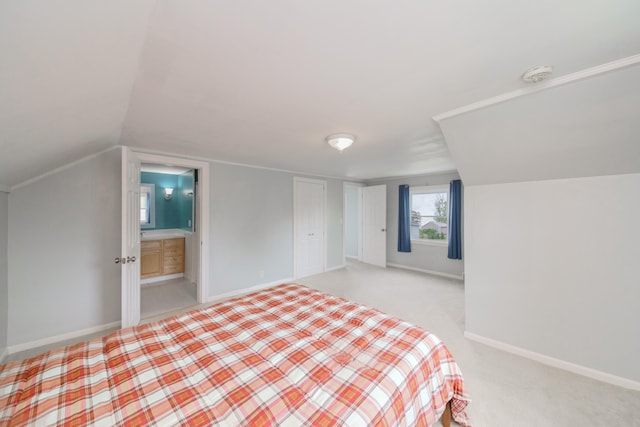 2720 Willa Dr, Saint Joseph, MI 49085 - bedroom featuring lofted ceiling, baseboards, ensuite bath, and light colored carpet