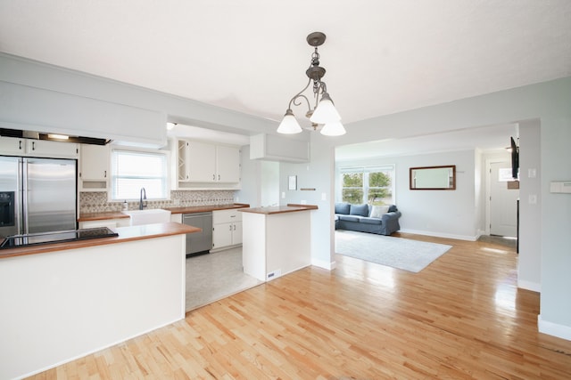 2720 Willa Dr, Saint Joseph, MI 49085 - kitchen with appliances with stainless steel finishes, a sink, open floor plan, white cabinetry, and a peninsula