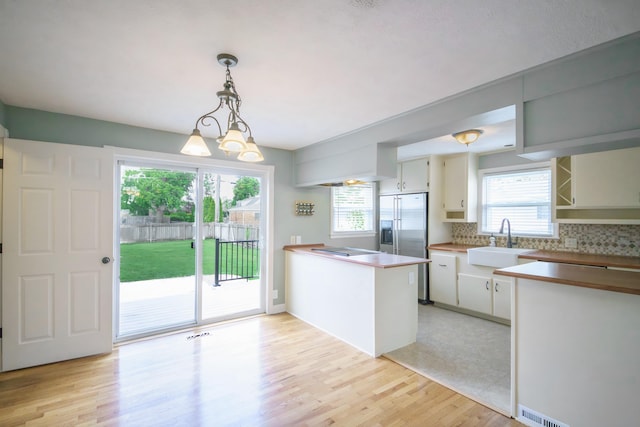 2720 Willa Dr, Saint Joseph, MI 49085 - kitchen featuring a sink, a peninsula, built in refrigerator, tasteful backsplash, and light wood-style flooring