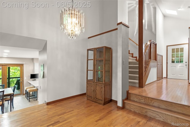 29915 Ardmore Dr, Farmington, MI 48334 - foyer entrance featuring high vaulted ceiling, a chandelier, stairway, light wood-style flooring, and baseboards