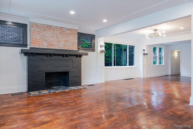 2270 W Philadelphia St, Detroit, MI 48206 - unfurnished living room with a tiled fireplace, a chandelier, wood finished floors, baseboards, and recessed lighting