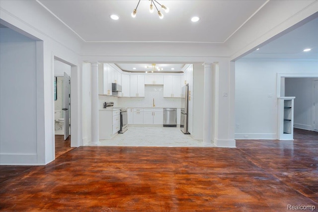 2270 W Philadelphia St, Detroit, MI 48206 - unfurnished living room featuring a chandelier, a sink, recessed lighting, decorative columns, and baseboards