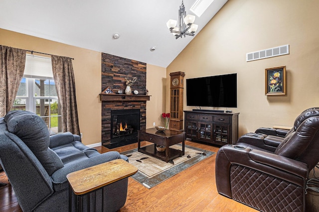 764 Allen Rd, Milan, MI 48160 - living area featuring wood finished floors, high vaulted ceiling, a fireplace, and a chandelier
