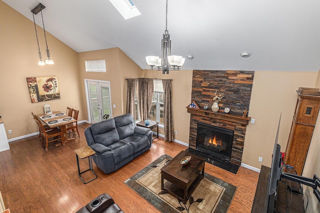 764 Allen Rd, Milan, MI 48160 - living room with a fireplace, a skylight, a chandelier, wood finished floors, and baseboards