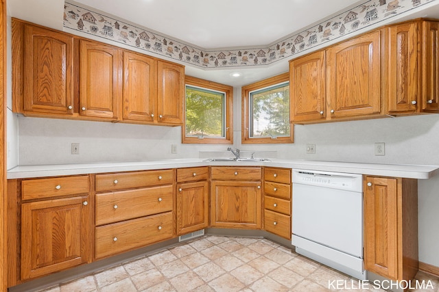 226 Palms St SW, Grand Rapids, MI 49548 - kitchen with dishwasher, brown cabinetry, a sink, and light countertops