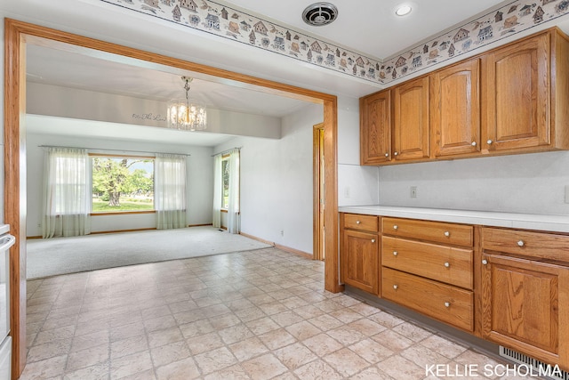 226 Palms St SW, Grand Rapids, MI 49548 - kitchen featuring baseboards, brown cabinetry, light countertops, open floor plan, and a chandelier