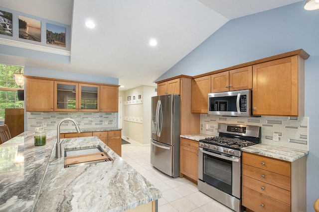 16448 Van Wagoner Rd, Spring Lake, MI 49456 - kitchen featuring stainless steel appliances, a sink, vaulted ceiling, light tile patterned flooring, and light stone countertops