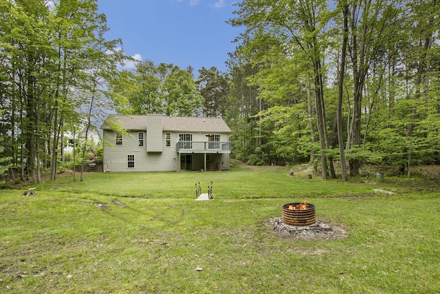 16448 Van Wagoner Rd, Spring Lake, MI 49456 - rear view of house with a fire pit, a yard, a chimney, and a wooden deck