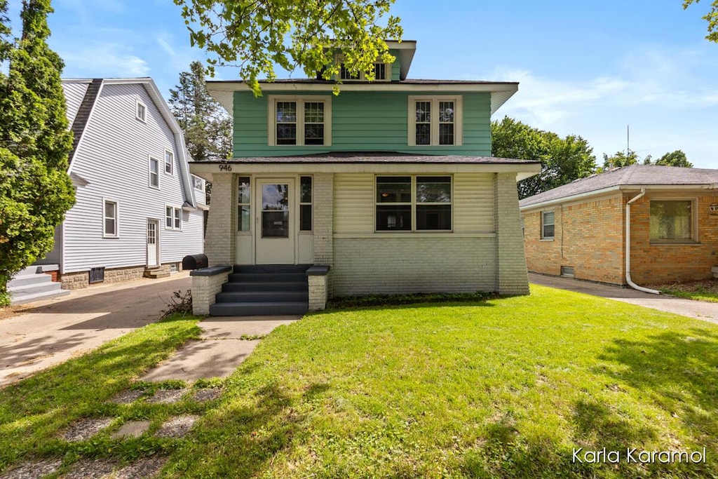 946 Lake Michigan Dr NW, Grand Rapids, MI 49504 - american foursquare style home featuring entry steps, brick siding, and a front lawn