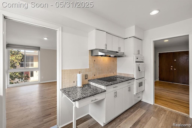 4041 W Maple Rd Apt 204, Bloomfield Hills, MI 48301 - kitchen with under cabinet range hood, black electric stovetop, white double oven, wood finished floors, and white cabinetry